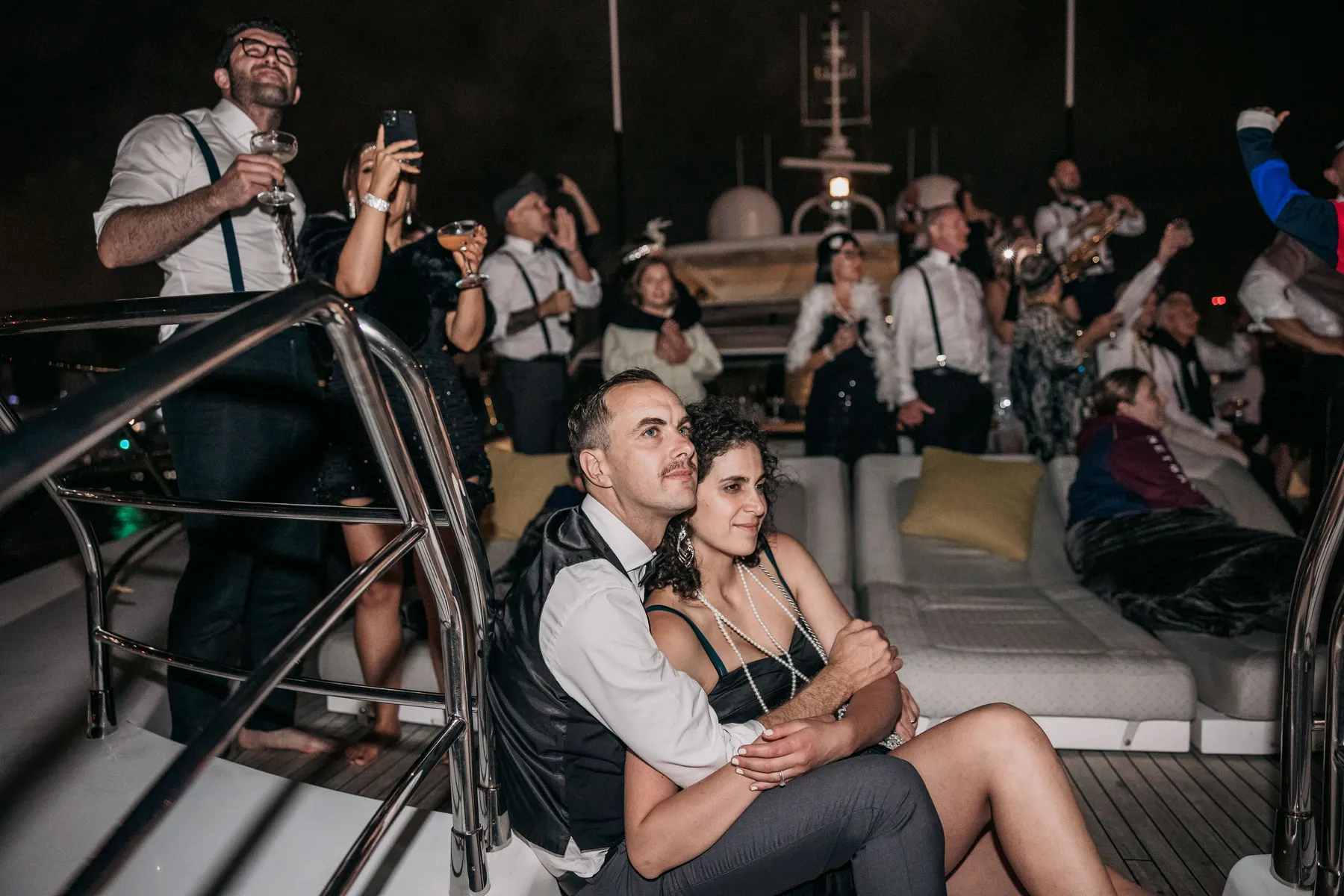 A couple sitting together on deck watching the last of the fireworks