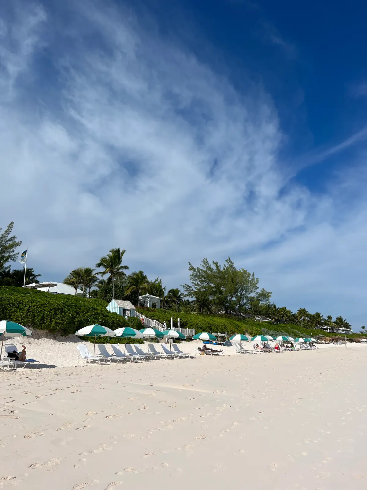 The Dunmore's green and white umbrellas on Pink Sands Beach