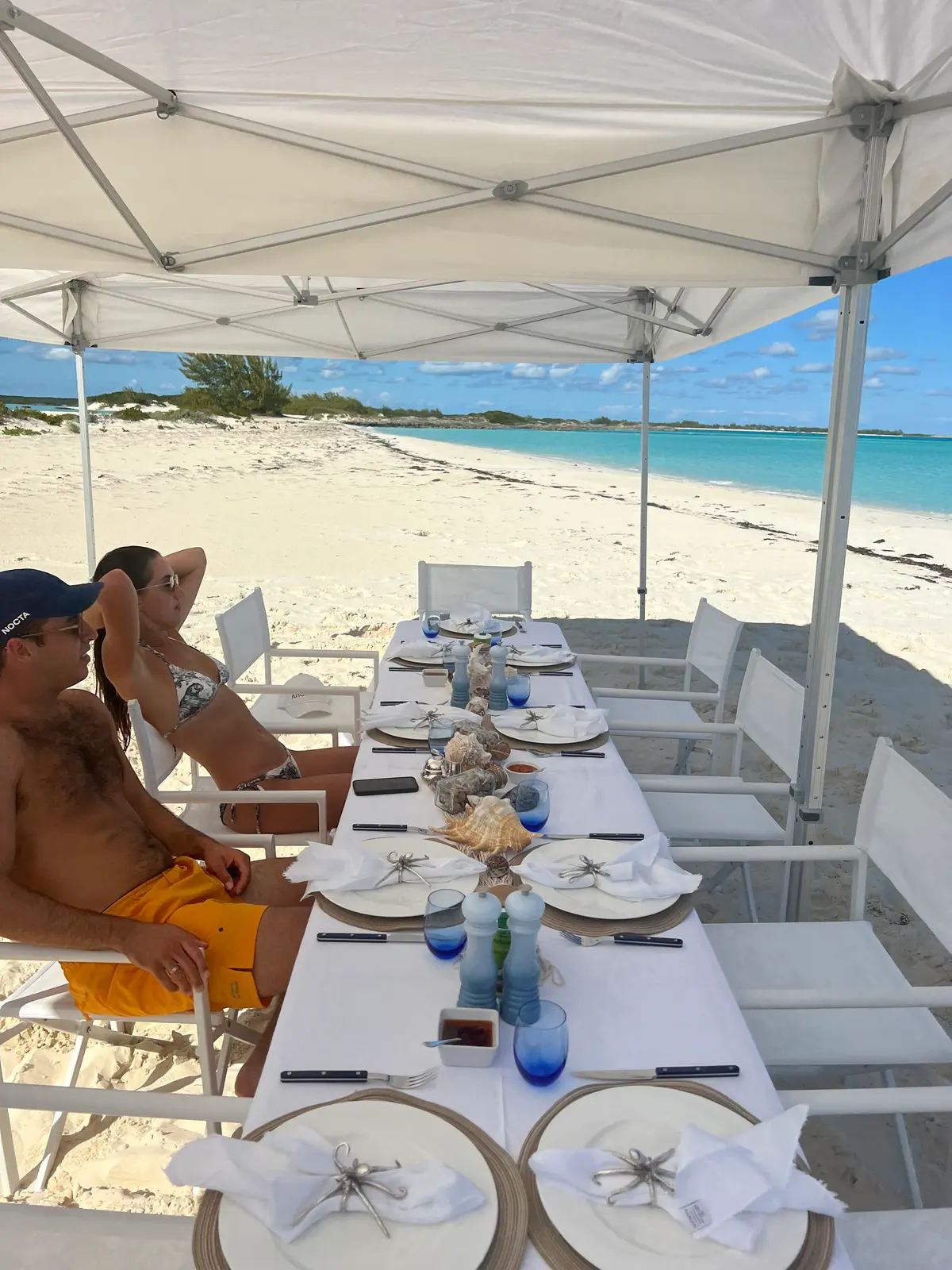 The long table under a white marquee on the sand at Pipe Cay